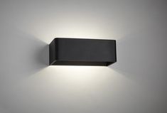 a wall light that is mounted on the side of a wall in an empty room