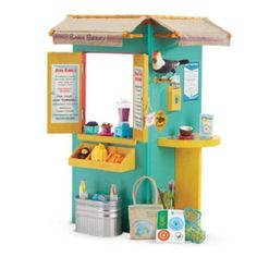 a toy doll house with furniture and accessories on the outside, including a small beach hut