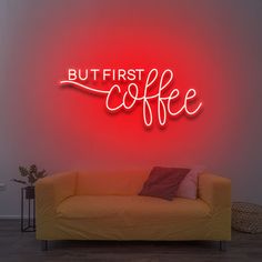 a neon sign that says but first coffee on the wall next to a couch in a living room