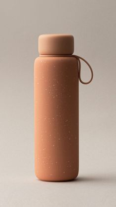 a bottle that is sitting on the ground next to a white wall and gray background