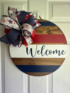 a welcome sign hanging on the front door with a bow around it's neck