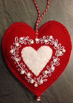 a red and white heart hanging on a wall