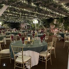 tables and chairs are set up for an event with lights strung from the ceiling above them