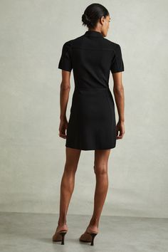 Find REISS Nala Knitted Zip-front Mini Dress on Editorialist. The Nala dress has a body-skimming knit fabric that traces the figure. A smart polo neckline features, leading to a zip-front closure that coordinates with the side zip pockets. Knitted construction. Zip-front closure. Side zipped pockets. Mini length Black, Nala Dress, Black Knit, Side Zip, Knitted Fabric, Knit Fabric, Zip Pockets, Mini Dress, Fabric