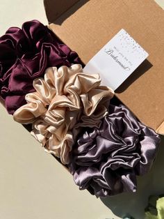 100% Mulberry Silk Scrunchie Your hair will fall in love with these ultra soft, trendy, versatile mulberry scrunchies!  If you purchase a set please write color  preference in comments  * Ultra soft  * No pulling, no snagging  * Promotes healthy hair * Helps reduce breakage * Sturdy elastic  * Luxe silk  * Chic  * For all hair types * One size fits all * Handmade with precision High Quality Luxe Bridal Tags FREE with purchase of scrunchie (please indicate in comment section which phrase you prefer)  * Self adhesive tags  * Elegant cursive * Sturdy cardstock Phrases Available: Team Bride To have and to hold your hair back  Thank You for being my bridesmaid  Will you be my Bridesmaid?  I can't tie the knot without you! Give the gift of healthy hair &  trendy hair accessory ❤️ Ponytail Scrunchie, Hair Accessories Ponytail, Silk Scrunchies, Scrunchies Hair, Hair Help, Bridesmaid Proposal Box, Tie Gifts, Hair Accessories Gift, Elastic Hair Ties