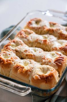 a casserole dish with meat and cheese in it sitting on a tablecloth