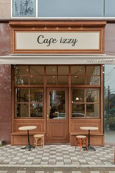 two wooden chairs sitting outside of a cafe