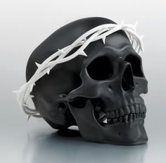 a black skull with a crown of white barbed wire on it's head is shown