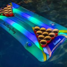 an inflatable raft filled with cups floating on top of water