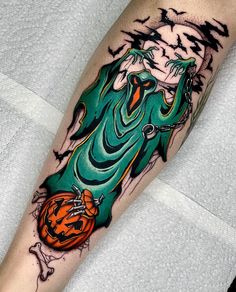 a person with a halloween themed tattoo on their arm