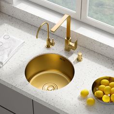 a kitchen sink that has some yellow balls in the bowl next to it and a window