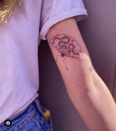 a woman's arm with a tattoo on it that has an image of a person holding