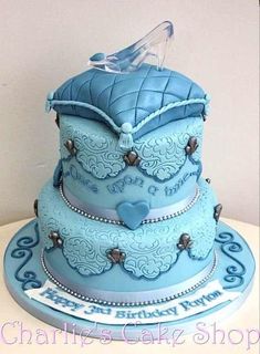 a three tiered cake with blue frosting and decorations