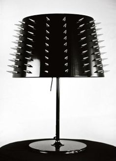 a black and white photo of a table lamp with spikes on the top of it