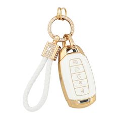 a gold and white keychain with a cell phone attached to the front of it