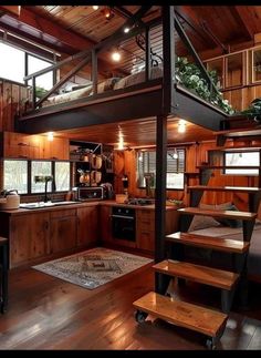 a kitchen with wooden floors and stairs leading up to the loft above it is also a living area