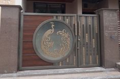 a large metal gate with a decorative design on the front and side of it, in front of a house