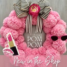 a pink pom - pom wreath with the words new in the shop