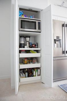 an organized pantry with stainless steel appliances and food in the fridge, along with other kitchen items