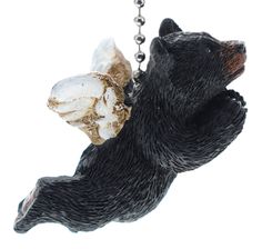 a bear ornament hanging from a chain with a piece of food in it's mouth