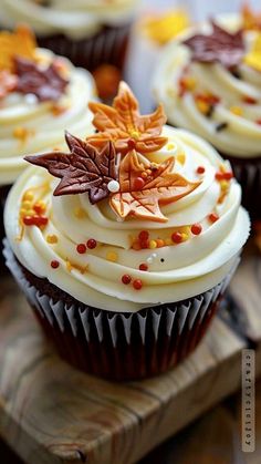 cupcakes decorated with white frosting and fall leaves