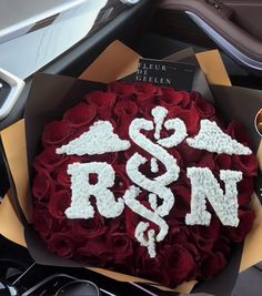 a bouquet of red roses with the letters r & n on it in a box