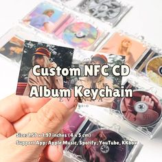 a person holding up a cd in front of several cds on a white background with the words custom ncd album keychain