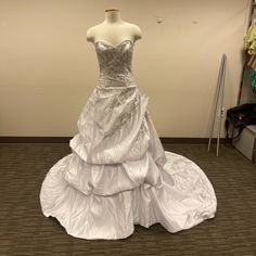 a white wedding dress on display in a room