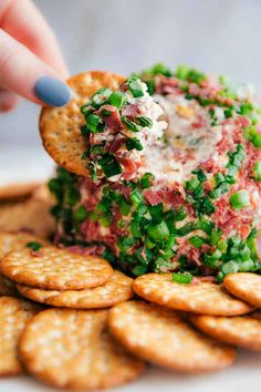 a cracker being dipped with crab salad on top of crackers