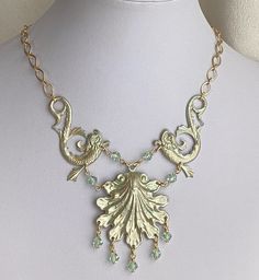 Are you a mermaid, or do you know someone who is?  Here is the perfect choker for you.  Two ornate dolphin (sea serpent?) stampings hold up a large  ornate scallop shell which have all been given a delicate sea green patina. Crystal sea-green bicones ornament the shell and make connectors between the shell and sea serpents.The centerpiece is about 5-1/2" long (tail to tail) and 2" deep (the shell is about 2" wide and across).  The rest of the length is of matte gold chain; it finishes with a lobster clasp so may be worn from about 16" to 18-1/2" (40-47cm).  If you need it longer or shorter, let me know and I can add or subtract chain at the ends. This might also make an interesting piece of jewelry for a wedding--mother of the bride or bridesmaid maybe. Sea Serpent, Mermaid Jewelry, Scallop Shells, Mermaid Necklace, Long Tail, Sea Green, Sea Foam, Matte Gold, Gold Chains