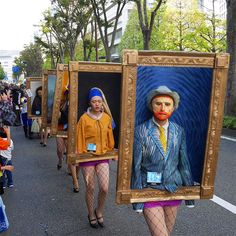 people are walking down the street with paintings on them