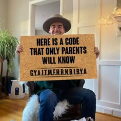 a man sitting in a chair holding a sign that says here is a code that only parents will know