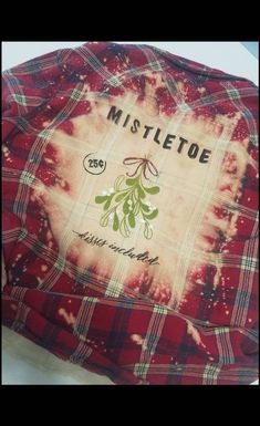 a red and white tie dye shirt with mistletoe on the front, sitting on top of a table