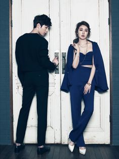 two people standing in front of a door with one person holding a cell phone and the other looking at something