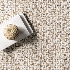 a close up view of a piece of carpet with a gold button on the end