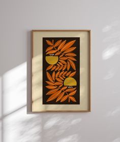 an orange and black painting hanging on the wall next to a window with sunlight coming through it