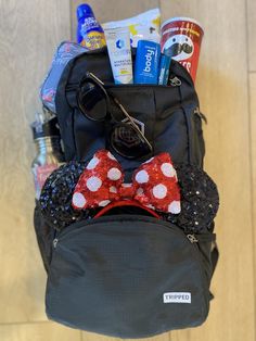 the back pack is packed with items such as sunscreen, toothpaste, and eyeglasses