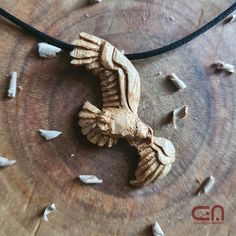 a wooden bird on a leather cord with other woodworking tools around it and some pieces of wood in the background