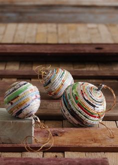 two balls of yarn sitting on top of a piece of wood next to a box