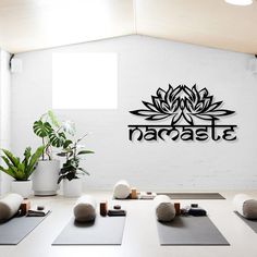 a room with yoga mats, rocks and plants in front of a sign that reads namaste