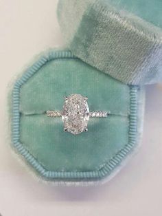 an oval cut diamond ring in a velvet box