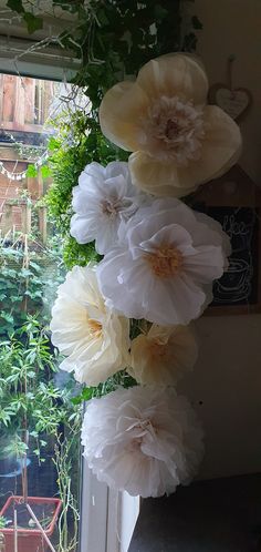 some white flowers are hanging from a window sill