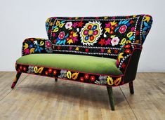 a colorful couch sitting on top of a wooden floor