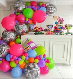 a room filled with lots of balloons and disco balls