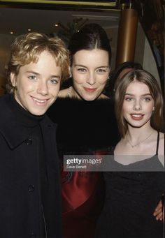 three people standing next to each other in front of a mirror at an event stock photo