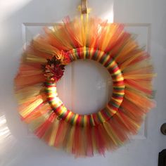 an orange and yellow wreath hanging on the front door