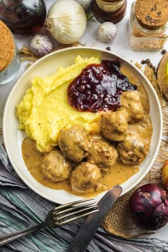 a white plate topped with meatballs and mashed potatoes