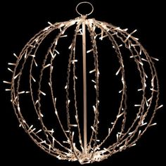 a ball with lights hanging from it's sides on a black background in the shape of a christmas ornament