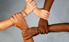 several people are holding hands together in a circle with their hands on top of each other