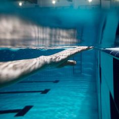 a man swimming in a pool with his hand on the edge